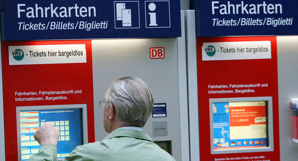 Ein Rentner steht vor einem Fahrkartenautomaten (Quelle: dpa).