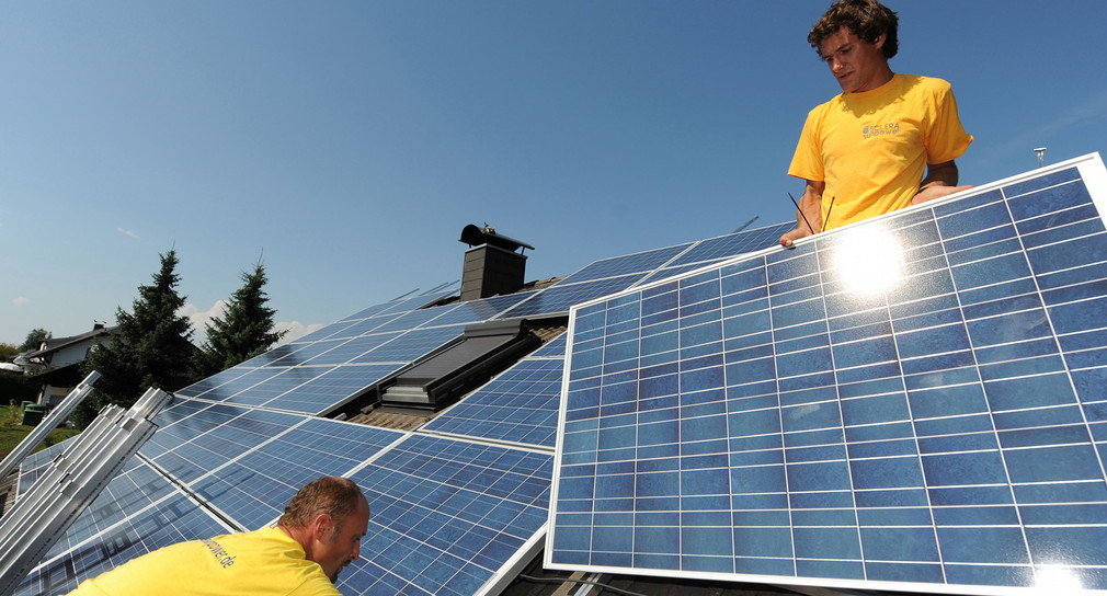 Zwei Monteure einer Firma für Solartechnik installieren auf einem Dach in Frittlingen (Zollernalbkreis) Solarpanele. (Bild: dpa)