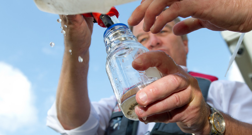 Umweltminister Franz Untersteller füllt Wasser, das auf Mikroplastik untersucht werden soll, in ein Laborglas. (Foto: © dpa)