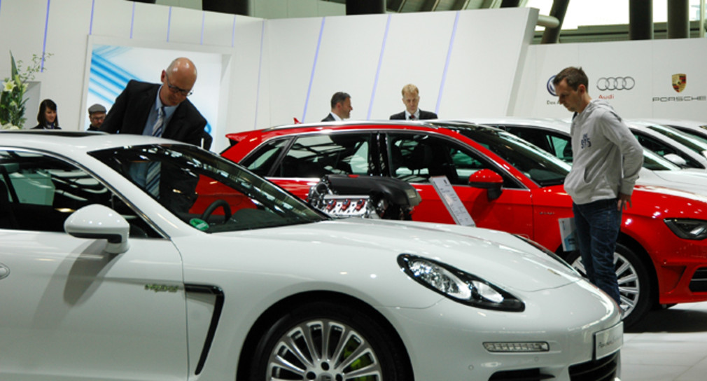 Besucher auf der i-mobility 2014 in Stuttgart betrachten einen Plug-in Hybriden von Porsche.