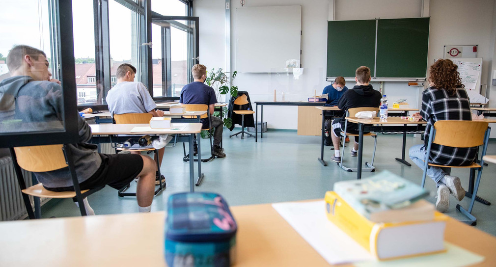 Schüler einer 10. Klasse sitzen in einem Klassenraum einer Gemeinschaftsschule und warten darauf, dass ihre Abschlussprüfung im Fach Deutsch startet. (Bild: © picture alliance/Christoph Schmidt/dpa)