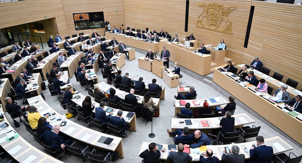 Abgeordnete des Landtags von Baden-Württemberg sitzen bei einer Debatte im Plenarsaal. 