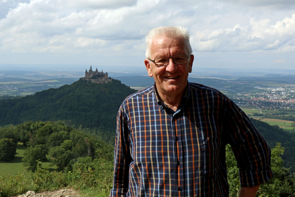 Ministerpräsident Winfried Kretschmann auf dem Zeller Horn, im Hintergrund die Burg Hohenzollern