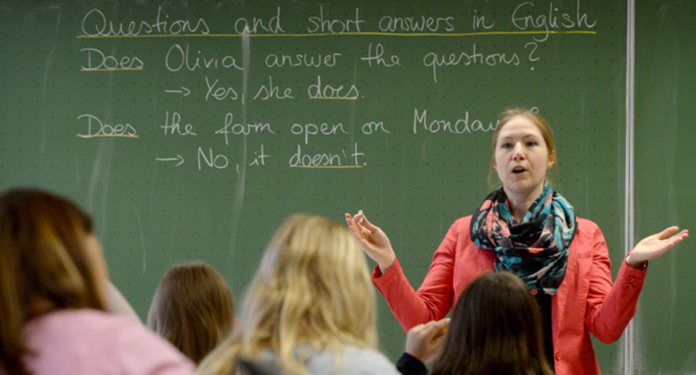 Eine Lehrerin steht vor einer Schulklasse an der Tafel. (Foto: © dpa)