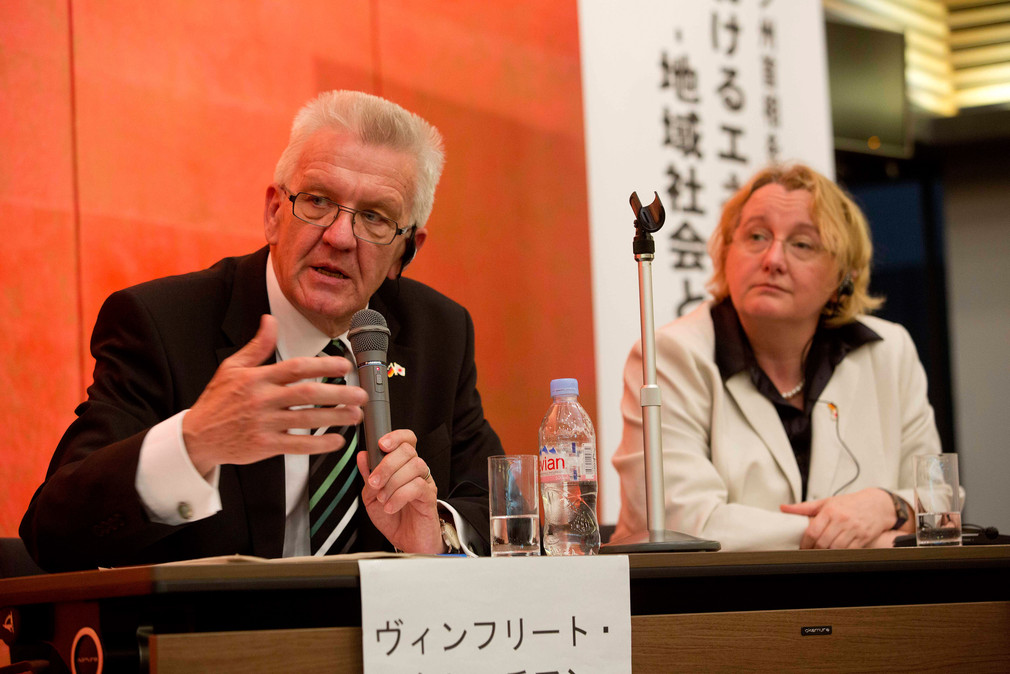Ministerpräsident Winfried Kretschmann (l.) spricht zur Energiewende und Bürgergesellschaft an der Kyoto-Universität (Japan); daneben sitzt Wissenschaftsministerin Theresia Bauer (r.).