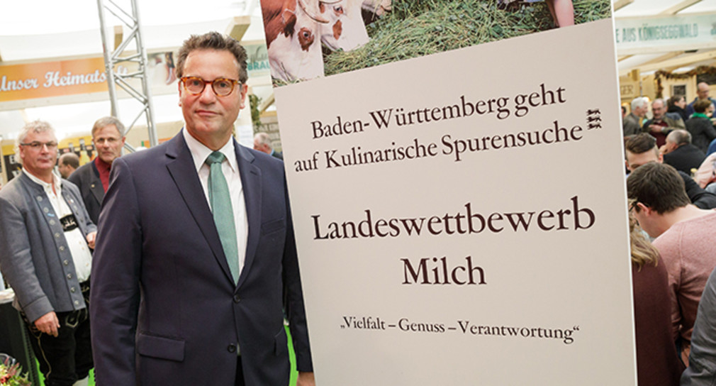 Landwirtschaftsminister Peter Hauk neben dem Banner zum Landeswettbewerb Milch (Foto: Ministerium für Ländlichen Raum und Verbraucherschutz Baden-Württemberg)