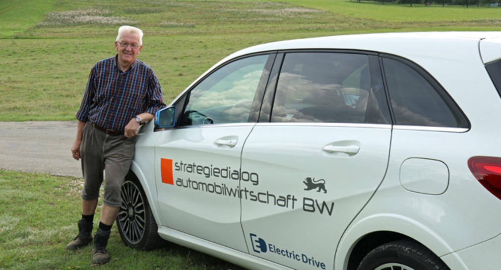 Ministerpräsident Winfried Kretschmann neben einem Elektrofahrzeug, mit dem er die Fahrstrecken zwischen den einzelnen Etappen zurücklegt (Foto: Staatsministerium Baden-Württemberg)