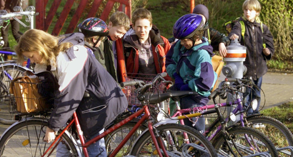 Schüler schließen ihre Fahrräder vor dem Unterichtsbeginn ab (Quelle: dpa).
