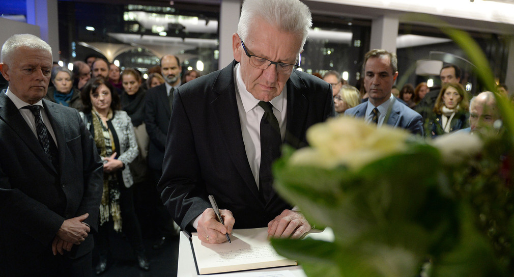 Ministerpräsident Winfried Kretschmann trägt sich  im französischen Generalkonsulat in Stuttgart in ein Kondolenzbuch zum Gedenken an die Opfer des Mordanschlags in Paris ein. (Foto: dpa)