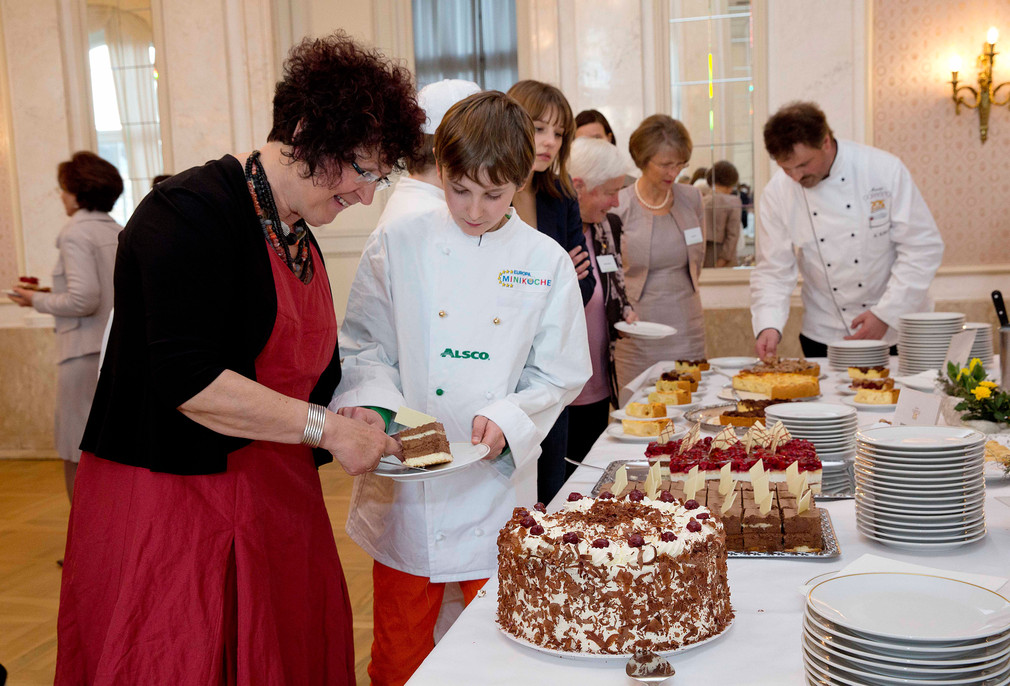 Gerlinde Kretschmann (l.) bekommt von einem Minikoch der Meistervereinigung Gastronom ein Stück Kuchen