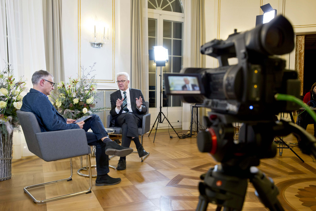 Ministerpräsident Winfried Kretschmann (r.) beantwortet Fragen bei der Online-Bürgersprechstunde