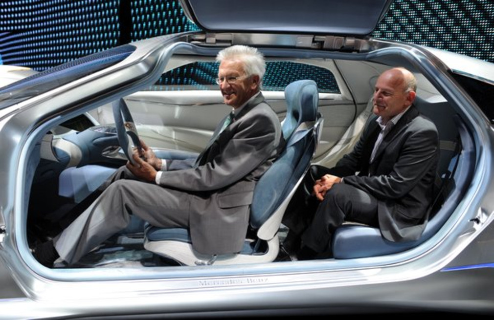 Ministerpräsident Winfried Kretschmann (l.) und Verkehrsminister Winfried Hermann (r.) sitzen bei ihrem Rundgang über die Internationale Automobil-Ausstellung (IAA) in Frankfurt am Main in der Halle von Mercedes-Benz in der Studie F125. (Foto: dpa)