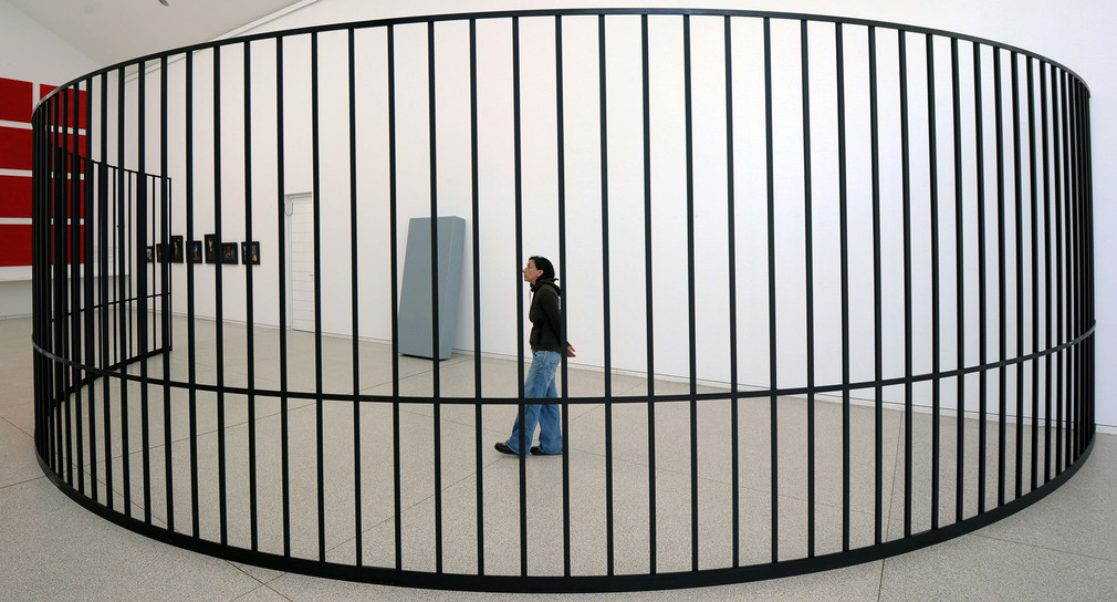 Eine Frau betrachtet in einer Ausstellung ein Stahlgitter im Kunstverein in Heidelberg. (Foto: © dpa)