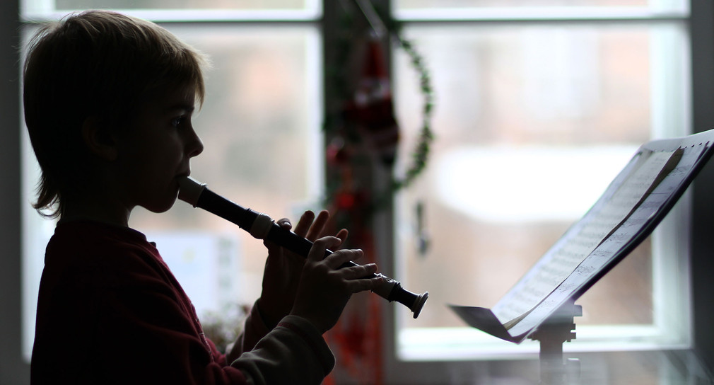 Ein Kind spielt eine Flöte.
