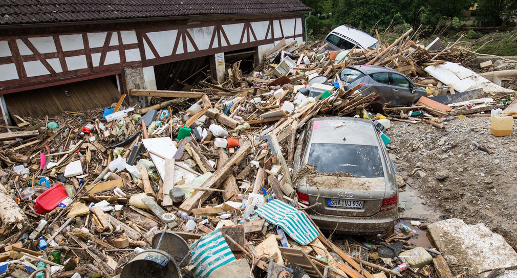 Trümmer und Autos liegen am 31. Mai 2016 nach einem schweren Unwetter in Braunsbach (Kreis Schwäbisch Hall/Baden-Württemberg) auf einer Fläche im Ort.