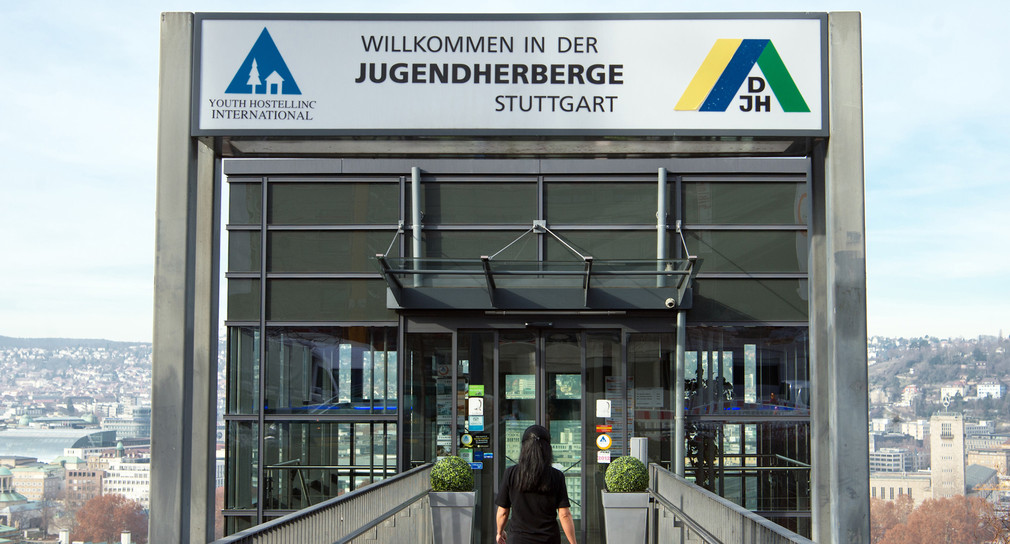 Eine Frau geht zum Eingang der Stuttgarter Jugendherberge. (Bild: picture alliance/Oliver Willikonsky/dpa)