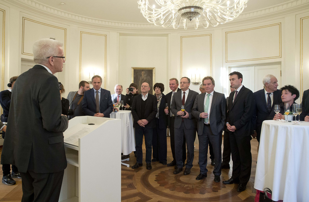 Ministerpräsident Winfried Kretschmann (l.) spricht zu den Kabinettsmitgliedern