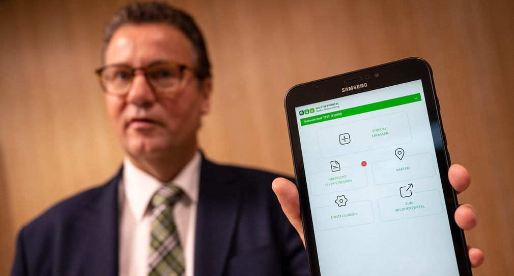 Forstminister Peter Hauk hält während der Vorstellung der App „Wildtierportal Baden-Württemberg“ ein Tablet in der Hand, auf dem die App läuft. 