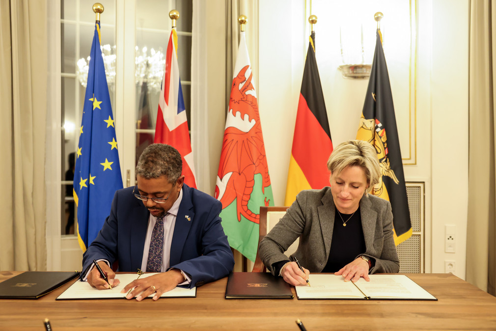 Wirtschaftsministerin Dr. Nicole Hoffmeister-Kraut (rechts) und der walisische Wirtschaftsminister Vaughan Gething (links) bei der Unterzeichnung einer gemeinsamen Erklärung zur Zusammenarbeit zwischen Baden-Württemberg und Wales.