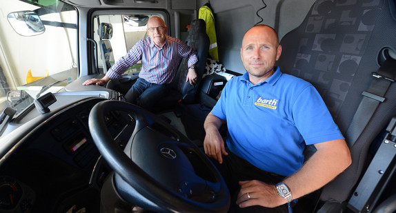 Verkehrsminister Winfried Hermann und der Lkw-Fahrer Martin Brander sitzen in einen Lkw. (Foto: dpa)