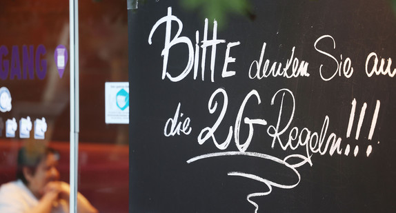 Ein Schild, das auf die 2G Regeln hinweist, hängt an einem Café.