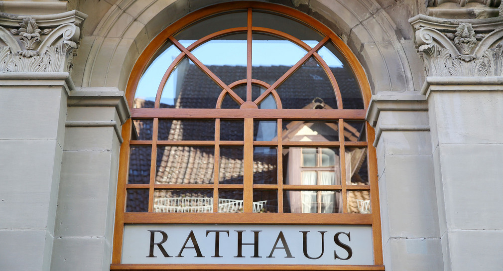 Über der Tür an einem historischen Gebäude steht „Rathaus“.