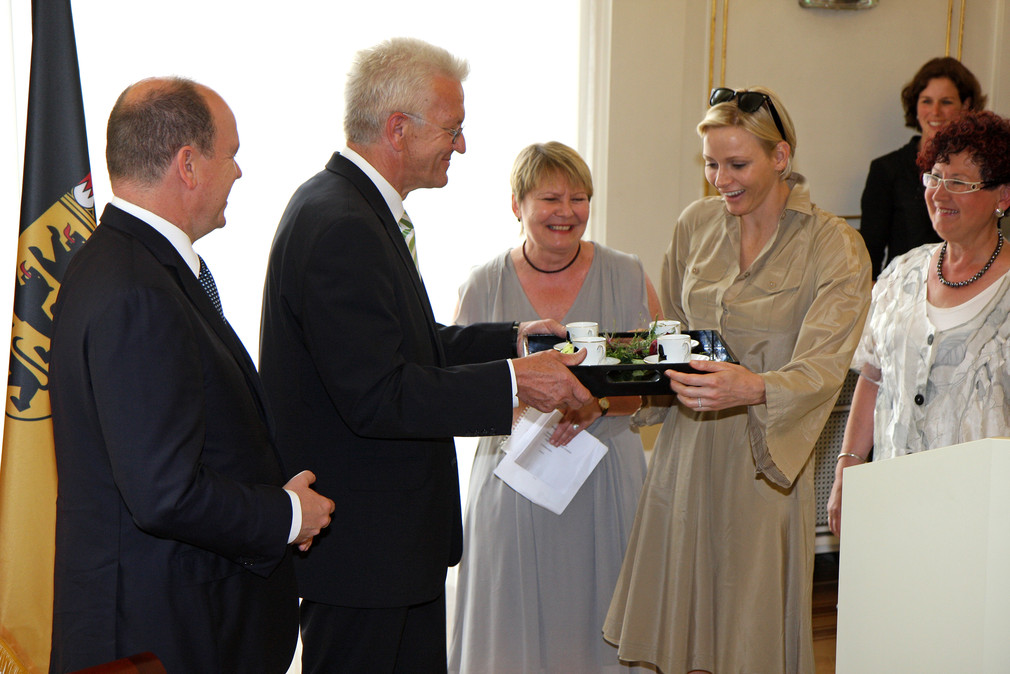 Ministerpräsident Winfried Kretschmann (2.v.l.) überreicht Fürstin Charlène von Monaco (2.v.r.) je zwei Mörike- und Schillertassen der Porzellanmanufaktur Ludwigsburg