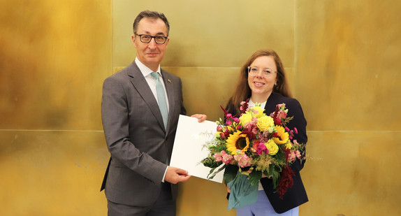 Ministerpräsident Cem Özdemir (links) und die neue Staatsministerin und Chefin der Staatskanzlei, Leonie Dirks (rechts) bei der Urkundenübergabe in der Villa Reitzenstein in Stuttgart