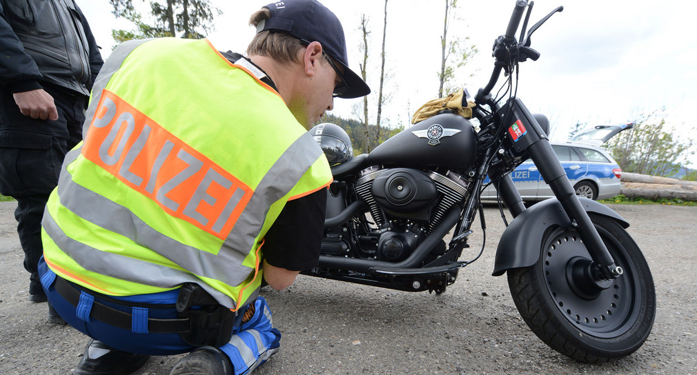 Polizist kontrolliert ein Motorrad (Foto: dpa)