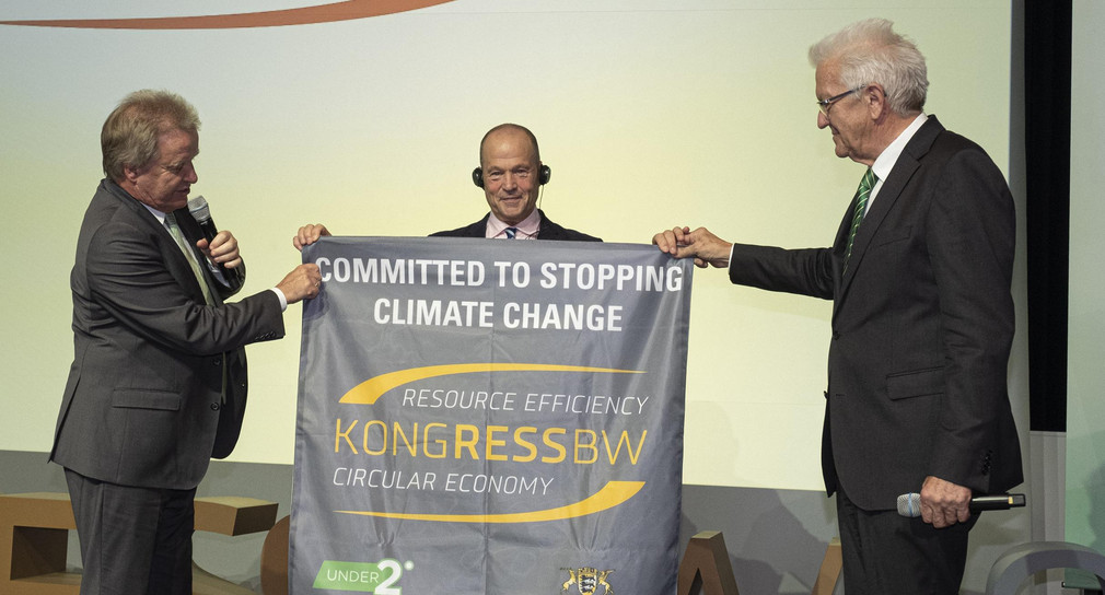 Umweltminister Franz Untersteller (links) und Ministerpräsident Winfried Kretschmann (rechts) haben dem Polarforscher und Umweltschützer Robert Swan eine Fahne aus Baden-Württemberg mit auf seinen Fußmarsch zum Südpol gegeben.