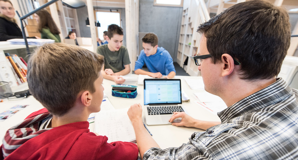 Neues Schuljahr 2019/2020 Mehr Informatikunterricht Ein Lehrer arbeitet mit Schülerinnen und Schülern an einem Tablet-PC. (Foto: © dpa)