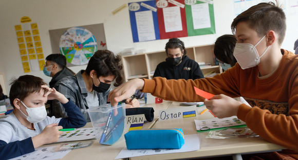 Geflüchtete Schüler*innen aus der Ukraine sitzen beim Unterricht mit Schülern aus anderen Ländern in einer Internationalen Klasse.