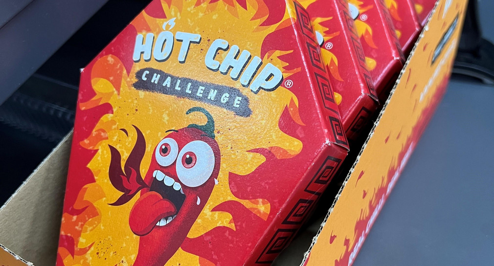 Mehrere Packungen der „Hot Chip Challenge“ liegen bei einem Kiosk neben der Kasse.