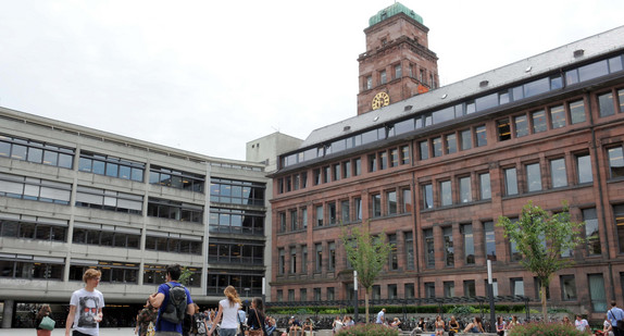 Studenten stehen in Freiburg vor einem Gebäude der Universität Freiburg. (Foto: © dpa)