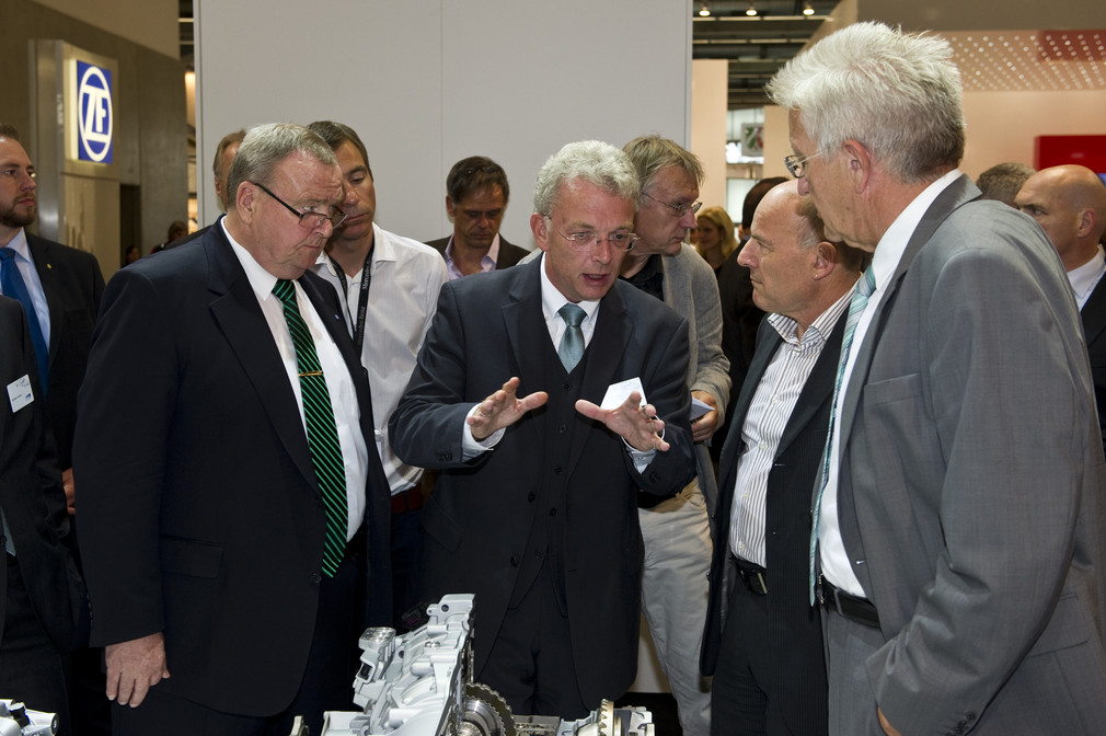 ZF Friedrichshafen-Chef Hans-Georg Härter (l.) mit Verkehrsminister Winfried Hermann (2.v.r.) und Ministerpräsident Winfried Kretschmann (r.) am Stand von ZF Friedrichshafen