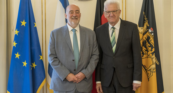 Ministerpräsident Winfried Kretschmann (rechts) und der israelische Botschafter Ron Prosor (links) stehen in der Villa Reitzenstein vor Fahnen.