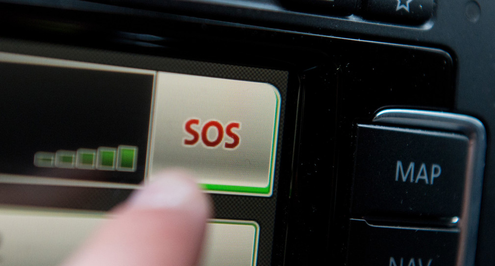 Ein Schriftzug "SOS" ist auf dem Display eines Bordcomputers mit Touchpad eines Volkswagens sehen. (Foto: © dpa)