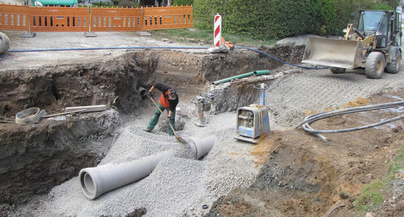Bauarbeiter verlegt Abwasserrohr in der Ortschaft Buch (Gemeinde Rot am See)