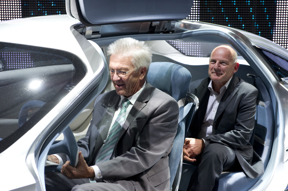 Ministerpräsident Winfried Kretschmann (l.) und Verkehrsminister Winfried Hermann (r.) sitzen am Daimler-Stand in der Studie F125