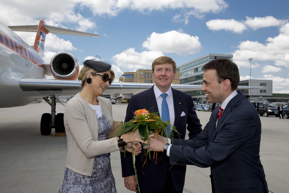 Finanz- und Wirtschaftsminister Dr. Nils Schmid (r.) begrüßt König Willem-Alexander (M.) und Königin Máxima der Niederlande (l.) am Flughafen.