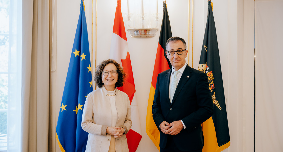Ministerpräsident Özdemir und die kanadische Botschafterin vor den Flaggen der Europäischen Union, Kanadas, Deutschlands und Baden-Württembergs.