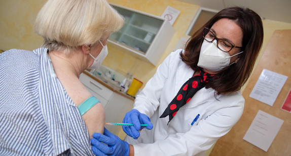 Eine Fachärztin für Allgemeinmedizin impft in ihrer Praxis eine Patientin gegen das Coronavirus.