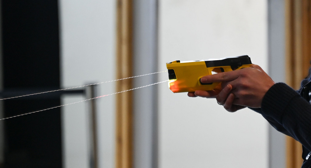 Eine Polizistin löst zur Demonstration einen sogenannten Taser aus.