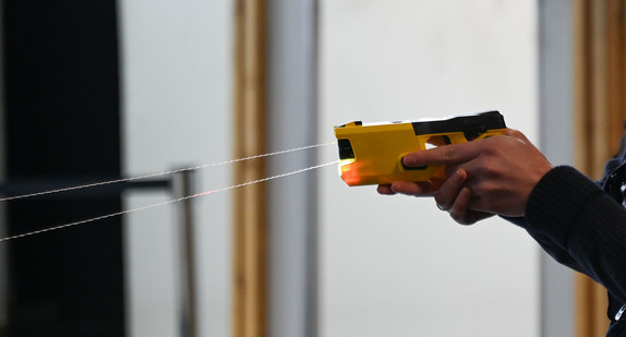 Eine Polizistin löst zur Demonstration einen sogenannten Taser aus.