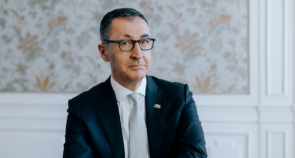 Portraitbild von Ministerpräsident Cem Özdemir, an einem Tisch sitzend.
