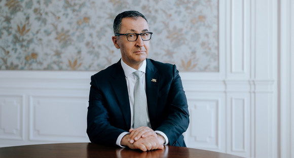 Portraitbild von Ministerpräsident Cem Özdemir, an einem Tisch sitzend.