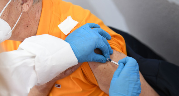 Ein Senior wird von einer medizinischen Fachkraft mit dem Pfizer-BioNTech-COVID-19-Impfstoff im Kreisimpfzentrum geimpft.