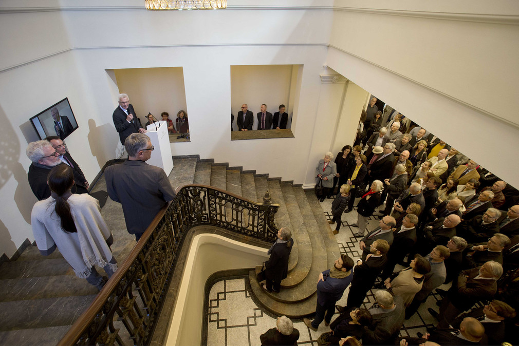 Ministerpräsident Winfried Kretschmann spricht im Foyer der Villa Reitzenstein vor den Gästen.
