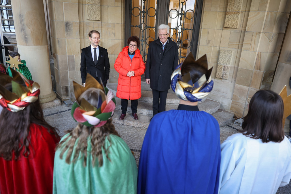Ministerpräsident Winfried Kretschmann, seine Ehefrau Gerlinde und Staatsminister Dr. Florian Stegmann empfangen die Sternsingerinnen und Sternsinger vor dem Eingang der Villa Reitzenstein.