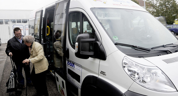 Ein Busfahrer hilft einem Fahrgast beim Aussteigen aus dem Bürgerbus der Gemeinde. (Foto: © dpa)